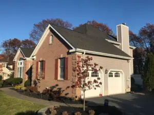 Side view of a large brick home showcasing the roof during a roof inspection near me.