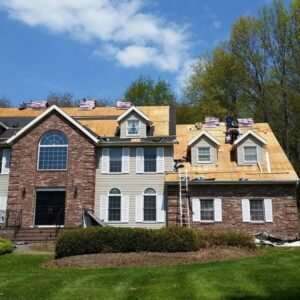 Roof installation on a large brick home by roofing Middletown, NJ.