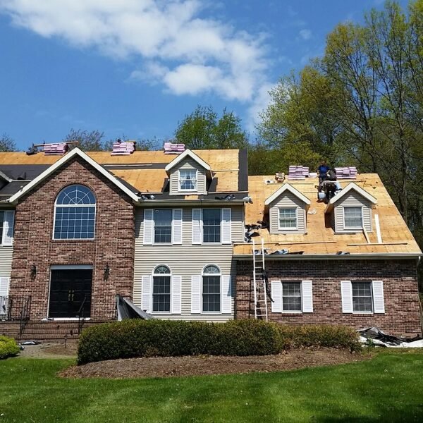 Roof installation on a large brick home by roofing Middletown, NJ.