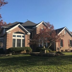 New black shingle roof on a large brick home by roofing companies in Middletown Township, NJ.